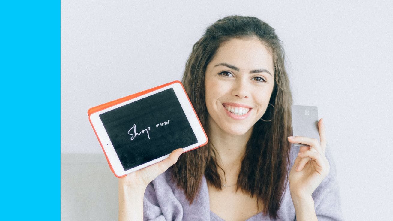 A person holding a tablet and a credit card