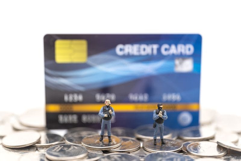 Armed action figures standing on change in front of a credit card, tyring to find Credit Card Processor for Your Gun Shop