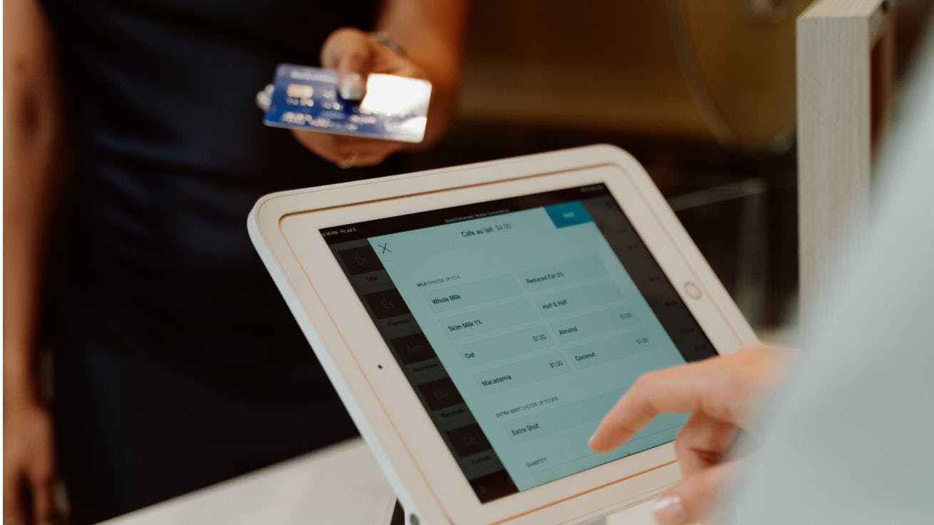 A person using a tablet to pay with a credit card