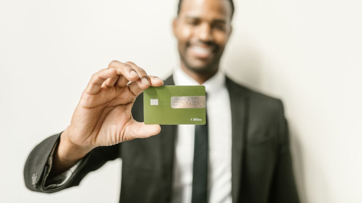 A person in a suit holding a credit card